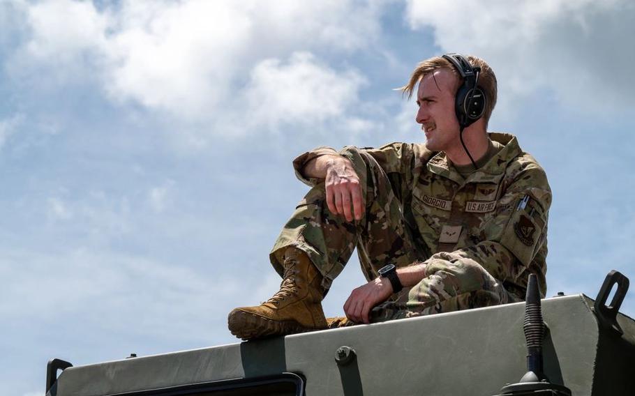 U.S. Air Force Airman 1st Class Andrew Giorgio, 36th Airlift Squadron loadmaster, sits atop a U.S. Marine Corps High Mobility Artillery Rocket System (HIMARS) during a HIMARS Rapid Insertion training at Kadena Air Base.